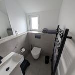 Badezimmer mit Toilette, Waschbecken und Heizkörper