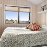 Bedroom with bed, window, and wooden walls.