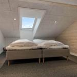 Room with sloped ceiling, double bed, and skylight.