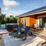 Deck with loungers, hot tub, and view of forest.