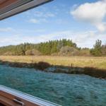Through the window, a frosted field and a forest under a blue sky are visible.
