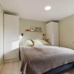 Bedroom with bed, wardrobes, and window.