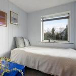 Bedroom with bed, window, and wall pictures.