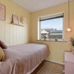 Bedroom with bed, window, and dresser. Walls are painted light.