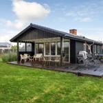 A house with terrace, garden and seating areas.