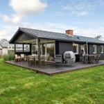 A house with terrace, garden and outdoor seating areas.