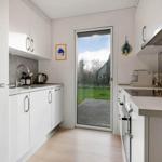 Kitchen with white cabinets, glass door to garden, and modern worktop.