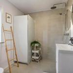 Bathroom with shower, sink, and bamboo ladder.