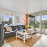 Living room with sofa, fireplace, and terrace with garden view.