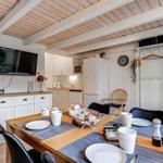 Dining area with table, chairs, and kitchen area in background.