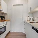 Kitchen with white cabinets, sink, stove, and dishwasher.