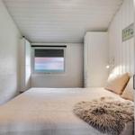 Bedroom with bed, wardrobes, and window.