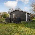 A small house with wooden siding and garden. Number 51 is displayed.