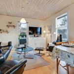 Living and dining area with sofa, TV, and table.