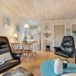 Living area with dining space, two black leather chairs, and hardwood floor.