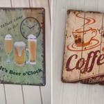 Two rustic wall signs with clock motifs and coffee design hang on a white wooden wall.