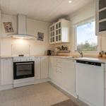 Kitchen with white cabinets, sink, refrigerator, and window.