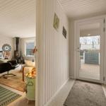 Entrance area with view into living and dining area with fireplace and seating.