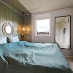 Bedroom with bed, window, and mirror on the wall.