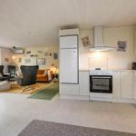 Kitchen with white cabinets and dining area with seating.
