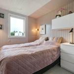 Bedroom with bed, dresser and window. Walls are panelled.