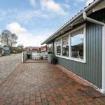 House with terrace, table and chairs, paved path and grass area