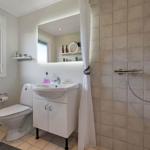 Bathroom with shower, sink and toilet. Window with frosted glass.