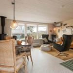 Living and dining area with seating and wood paneling.