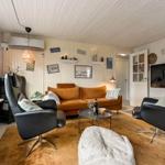 Living room with sofa, two chairs, and TV mounted on the wall.