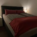 Schlafzimmer mit Doppelbett, zwei Nachttischen und Lampen.