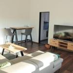 Wohnzimmer mit Sofa, TV und Essbereich. Küche im Hintergrund sichtbar.