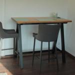 Hochwertiger Esstisch mit zwei Barhockern und einer Kerze.