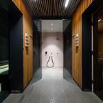 Flur mit Dusche und Sauna, Holzwand und Bodenfliesen