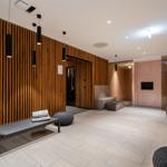 Moderne Wellnessbereich mit Holzwand, Duschen und Liegeflächen.