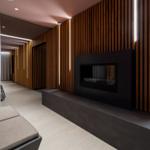 Moderne Lounge mit Holzwand, Kamin und Sitzbank.