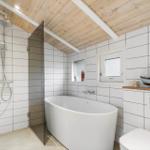 Bathroom with freestanding bathtub, shower, and model boat.