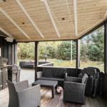 Deck with seating, grill, and view of forest.