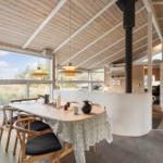 Dining area with wooden table, chairs, and large window view.
