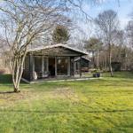 Modern cabin with large glass area and terrace in the woods.