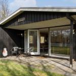 Wooden cabin with terrace, seating area, and garden table. Entrance to interior.