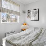 Bedroom with bed, window, and wall decor.