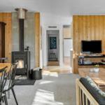 Living and dining area with fireplace, sofa, and TV.