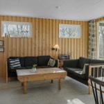 Living room with two sofas, wooden table, and large window to terrace.