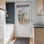 Kitchen with fridge, sink, and door to outdoor area.
