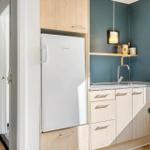 Kitchen with refrigerator, worktop, and sink.