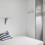 Bedroom with bed, coat hooks, and window.