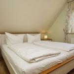 Schlafzimmer mit Doppelbett, Nachttischen und Fenster mit Blick.