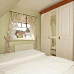 Schlafzimmer mit Doppelbett, Kleiderschrank und Fenster mit Blick.