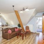 Wohn- und Essbereich mit Sofa, Tisch und Balkontür.