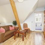 Wohnzimmer mit braunem Sofa, Holzfußboden und Kaminholzstruktur.